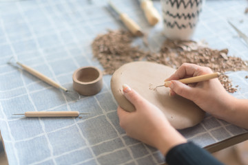 Pottery workshop, the process of making ceramic tableware, women's hands