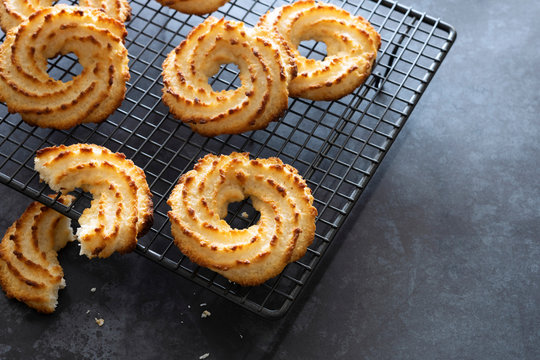 Golden coconut macaroon cookies cooling on a wire rack.