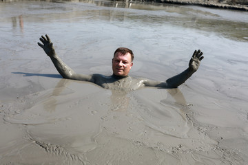 Man standing in mud pond