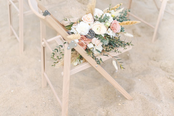 Wedding bouquets on wooden chair onseaside