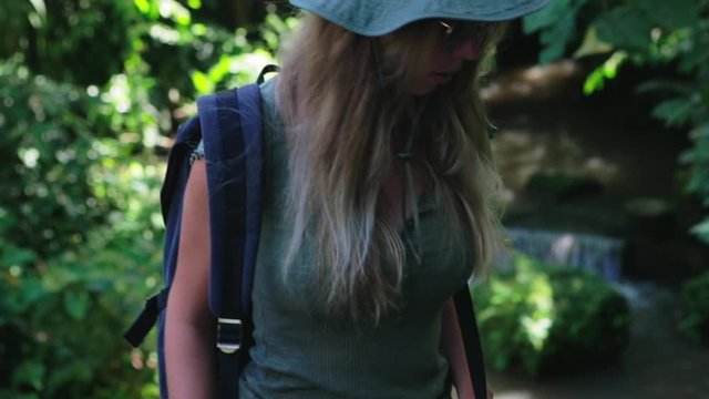 Young beautiful woman walking up the stairs in the jungle. Happy tourist girl on vacation. Lifestyle backpack tourist travel alone on holiday. An independent female researcher in Asia.