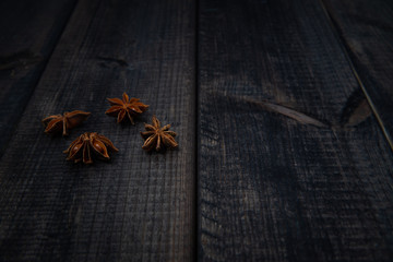Anise stars on a dark wooden table. The concept of using spices for dishes, enriching the taste.