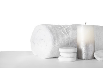Towel, spa stones and candle isolated on white