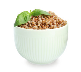 Bowl of buckwheat porridge with basil isolated on white