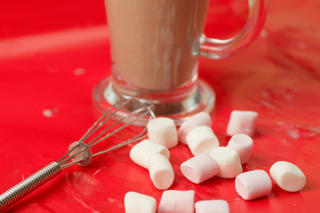  Glass mug of hot chocolate with marshmallows and whisk 
