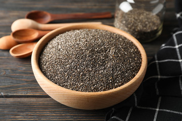 Chia in wooden bowl on wood background, close up