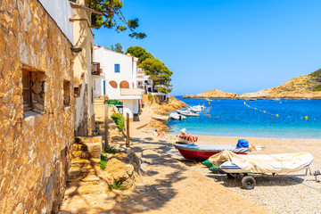 Fishing boats on beach in Sa Tuna village with colorful houses on shore, Costa Brava, Catalonia, Spain
