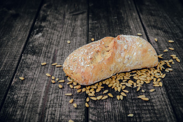 Fresh rolls on a dark wooden background. The concept of baking bread, eating meals with rolls, bread. Product made of wheat and rye flour, bread preparation. Eating sandwiches.
