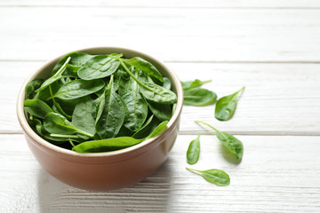 Fresh green healthy spinach on white wooden table. Space for text