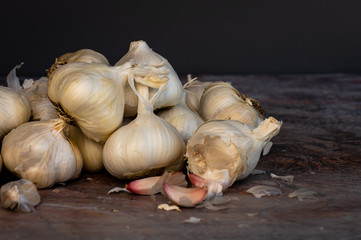 Group of garlic bulbs and cloves on a textured surface and gray background