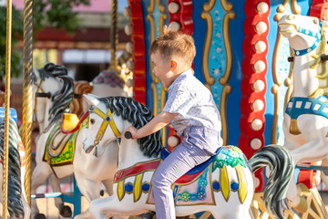 Smiling child riding a toy horse carousel 
