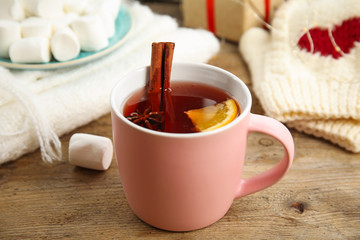 Cup of hot mulled wine on wooden table. Winter drink