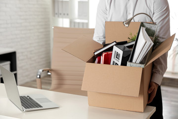 Young man with box of stuff in office, closeup