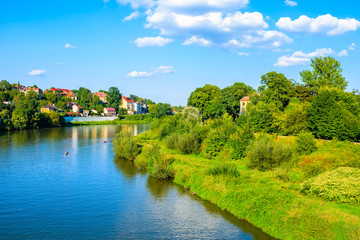 Obraz premium View of Vistula river with houses in background on sunny summer day, Krakow, Poland