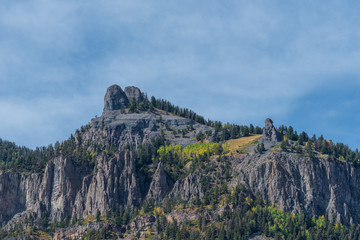 Low angle landscape of grey stone mountain tops with some yellow aspen trees near Ouray, Colorado