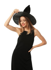 Beautiful young woman wearing witch costume for Halloween party on white background