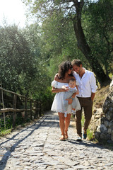 Naklejka na ściany i meble Young beautiful family walks in the Park in Italy