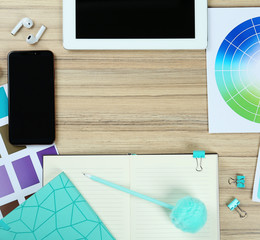 Flat lay composition with digital devices and color palettes on wooden background, space for text. Graphic designer's workplace