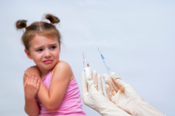 Doctor doing vaccine injection to crying girl