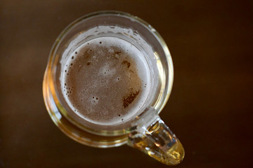 beer glass from above with delicious yellow drink and foam