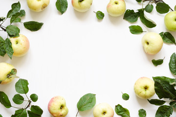 Fresh apples green leaves on white wooden background