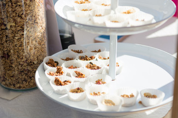 Delicious granola placed in paper cups for tasting healthy snack.