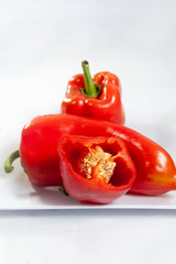 Half red bell pepper in the foreground focused.Selective focus.Vertical. Seen up close. White background.