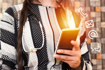 Business doctor woman with stethoscope with braid hair holding smart phone with icon mobile phone, mail, telephone and address. Customer service call center contact us concept