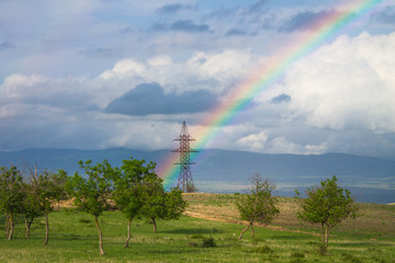 Beautiful landscape with rainbow over power pylon - 293219111