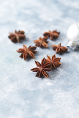 Star anise and Christmas ball on bright wooden background. Copy space. 