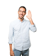 Fototapeta premium Happy young man smiling and making a gesture of trying to hear something