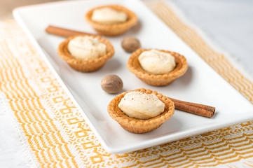 Homemade butter tart dessert. Mini sugar pies (or butter tarts) with a crisp pastry crust, a sweet filling and pumpkin spice whipped cream on top. A tasty dessert for fall holidays like halloween!