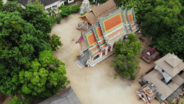 Classic Buddhist temple between forest. From above drone view classic Buddhist monastery between green trees near hill in Thailand. Koh Samui. concept of tourism, meditation and oriental life.