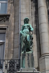 Graceful statue at the exterior of an old building, in Anvers, Belgium