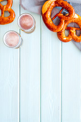 Octoberfest table background. Pretzels and beer glasses on blue wooden background top view frame space for text