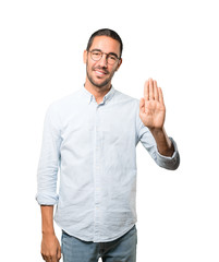 Happy young man making a gesture of stop with his palm