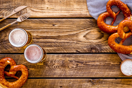 Octoberfest table background. Pretzels and beer glasses on dark wooden background top view frame space for text