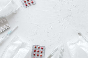 Treat flu and cold concept. Vaccine, mask, pills on white background top view frame copy space