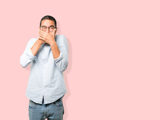 Young man covering his mouth with his hands