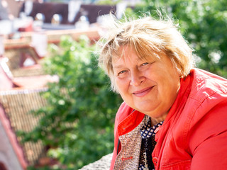 Mature woman in red walking around the old town. Tallinn