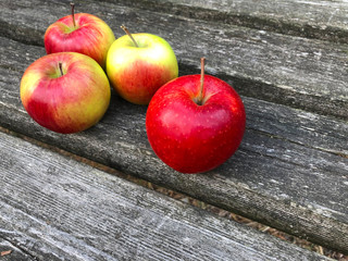 Fresh red apples on a wooden table. Separately lying ripe apples on a wooden background.