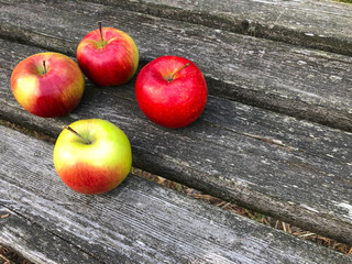 Fresh red apples on a wooden table. Separately lying ripe apples on a wooden background.
