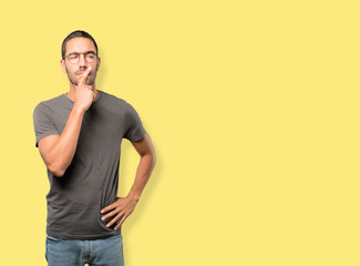 Concentrated young man making a gesture of distrust