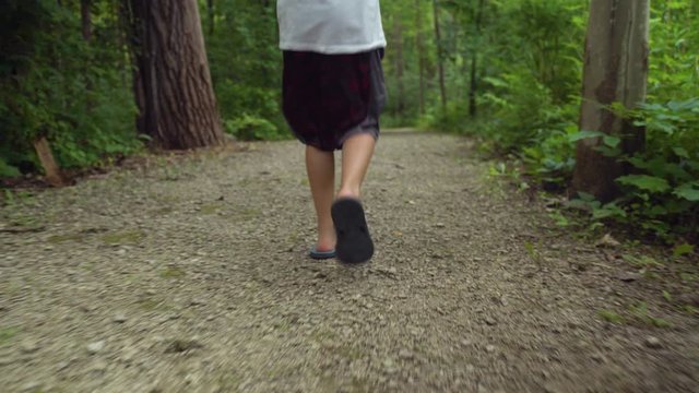 Shot of a boy's feet walking on a trail in the park