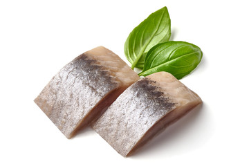 Salted marinated Atlantic herring with fresh green basil, isolated on white background
