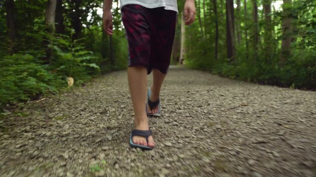 A boy's feet on a trail in the forest