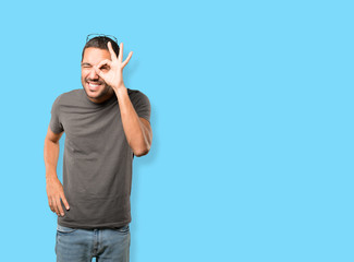 Happy young man using his hands like a binoculars