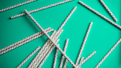 Stack of paper straws on green background