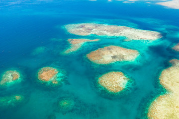 Coral reefs and lagoons, top view. Atolls and turquoise sea water. Sea surface.