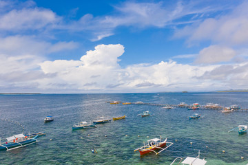 Seascape with boats and clouds. Many tourist boats in the bay during the day. Siargao, Philippines, view from above.